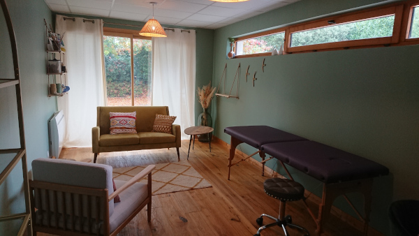 Bureau dans les tons vert avec un divan un fauteuil et une table de massage